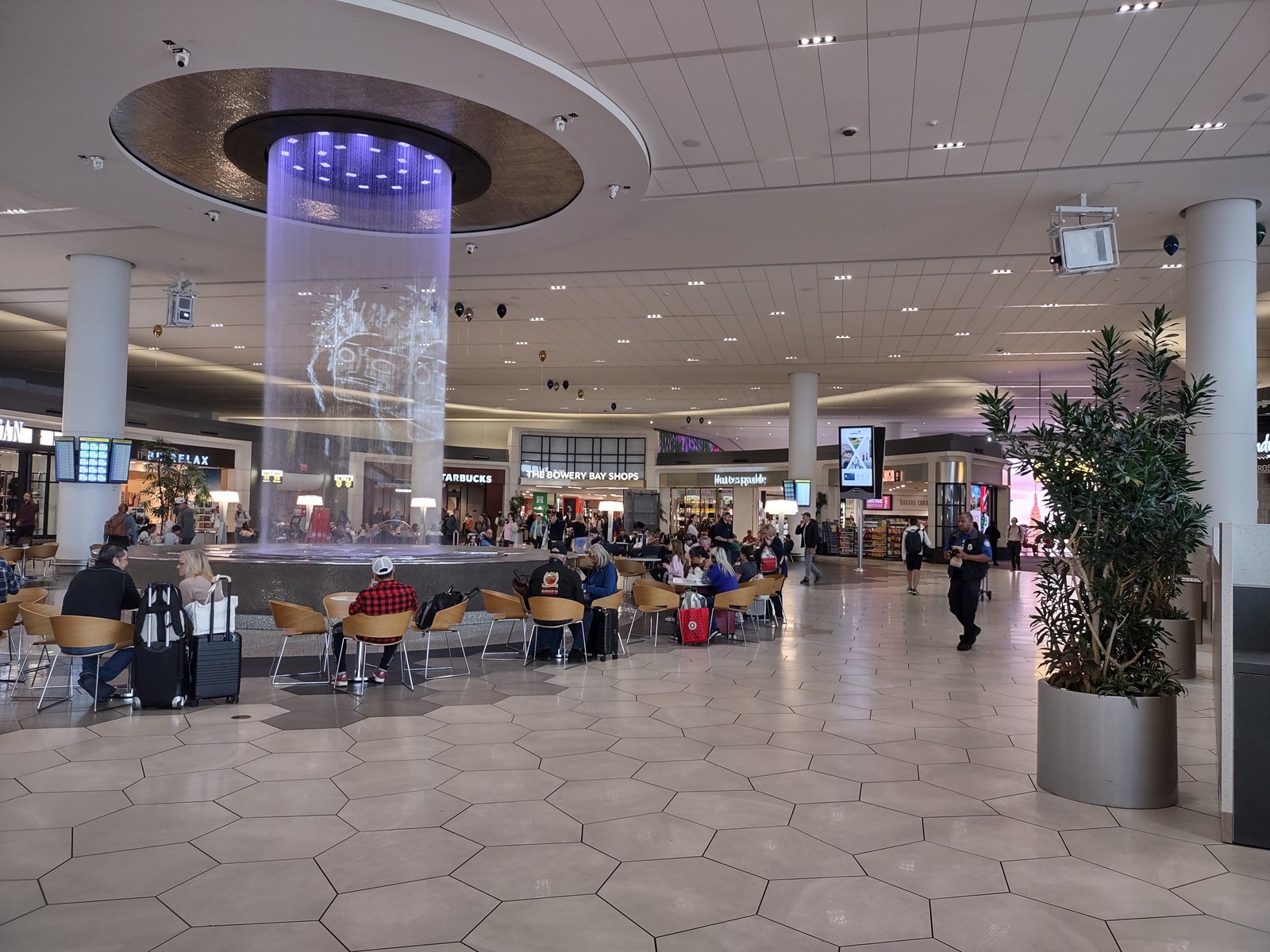 Interior photograph of the Terminal B food hall in October 2024 with seating, food counters, and overhead signage